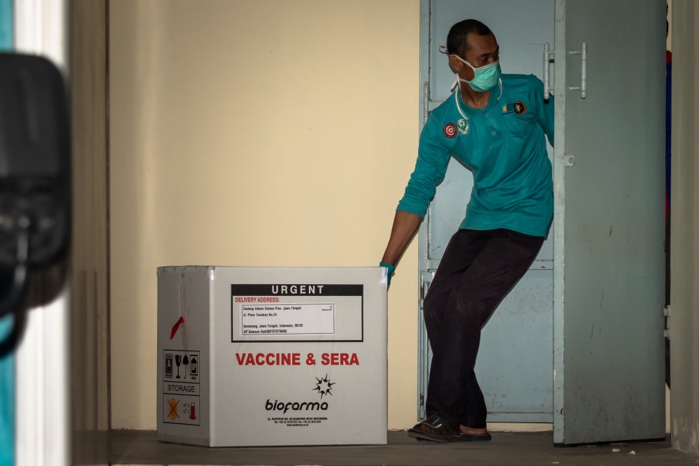 An officer moves a box of Sinovac's vaccine for coronavirus disease (COVID-19) from Biofarma to the pharmacy storage room of the local health department, as it is arrives in Semarang, Central Java province, Indonesia, January 4, 2021 in this photo taken b
