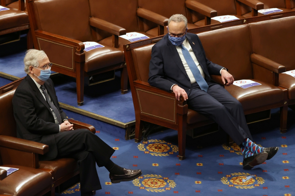 Senate Majority Leader Mitch McConnell (L) and Senate Democratic Leader Chuck Schumer are seen during a joint session of Congress after they reconvened to certify the Electoral College votes of the 2020 presidential election in the House chamber in Washin