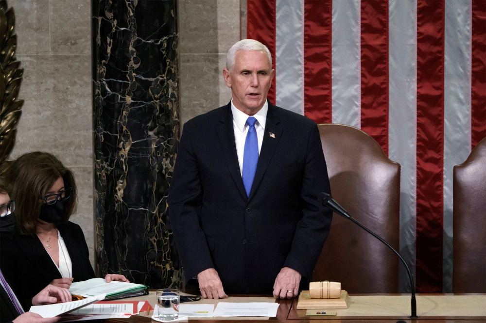 US Vice President Mike Pence reads the final certification of Electoral College votes cast in November's presidential election during a joint session of Congress at the Capitol in Washington, US, January 7, 2021. J Scott Applewhite/Pool via Reuters 