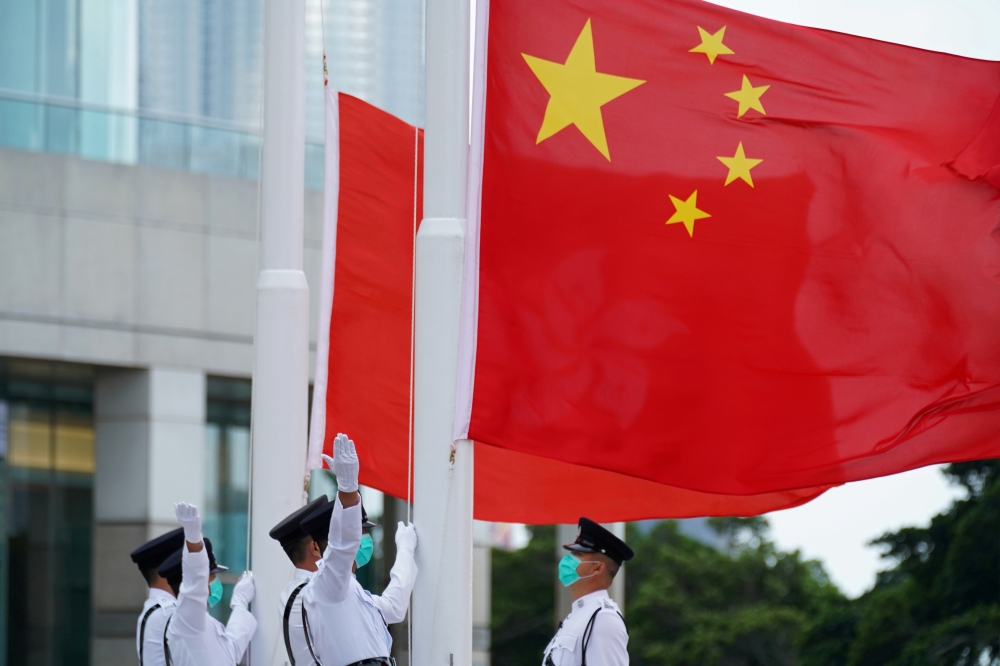Members of the Hong Kong Police Honour Guard raise flags during a flag-raising ceremony marking China's National Day in Hong Kong, China October 1, 2020. Reuters/Lam Yik/File Photo