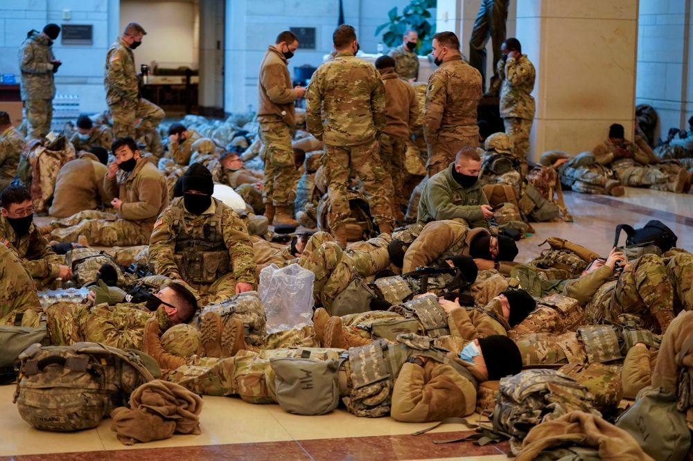 National Guard members gather and rest, before Democrats begin debating one article of impeachment against U.S. President Donald Trump at the U.S. Capitol, in Washington, U.S., January 13, 2021. REUTERS/Joshua Roberts
