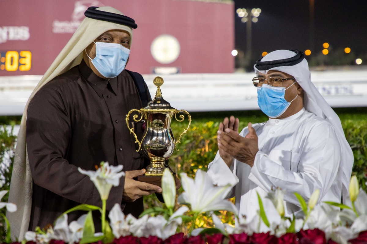 QREC Racing Manager Abdulla Rashid Al Kubaisi presenting the Muaither Cup to the winning team's representative. 