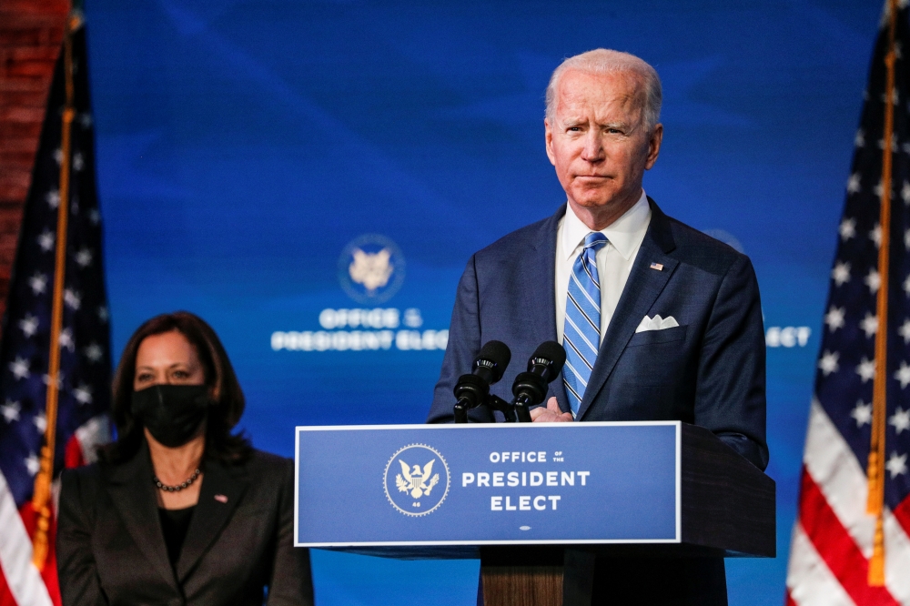 U.S. President-elect Joe Biden delivers remarks as Vice President-elect Kamala Harris looks on during a televised speech on the current economic and health crises at The Queen Theatre in Wilmington, Delaware, U.S., January 14, 2021. REUTERS/Tom Brenner