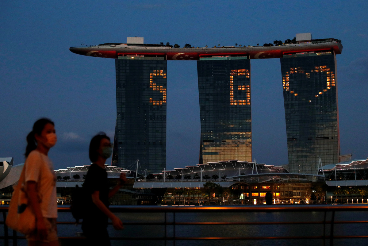 FILE PHOTO: The Marina Bay Sands integrated resort lights up in tribute to the healthcare workers and people staying home to curb the spread of the coronavirus disease (COVID-19) outbreak in Singapore, April 10, 2020. REUTERS/Edgar Su/File Photo

