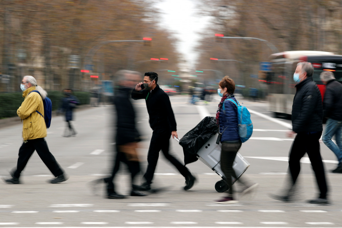 Pedestrians wearing face masks cross a street in the city center, during the coronavirus disease (COVID-19) outbreak, in Barcelona, Spain, January 18, 2021. REUTERS/Albert Gea
