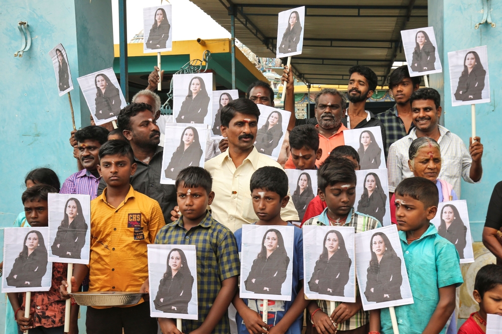 People holding placards with the photo of Vice President-elect Kamala Harris celebrate on the day of her inauguration in the village of Thulasendrapuram, where Harris' maternal grandfather was born and grew up, in the southern Indian state of Tamil Nadu, 