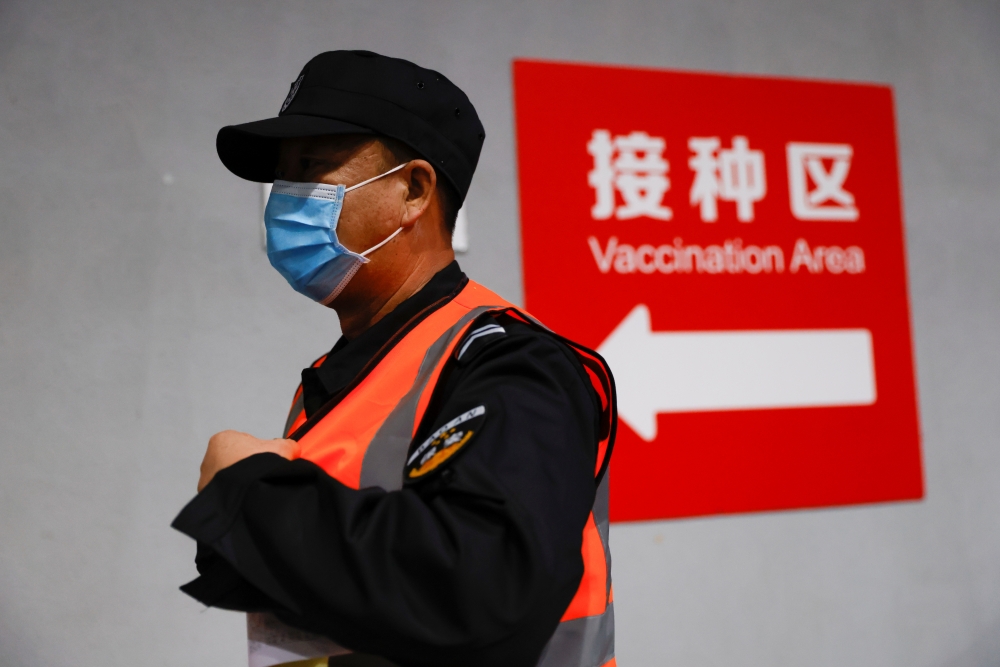 A man walks to receive a dose of a coronavirus disease (COVID-19) vaccine at a vaccination site, during a government-organized visit, in Beijing, China January 15, 2021. REUTERS/Carlos Garcia Rawlins