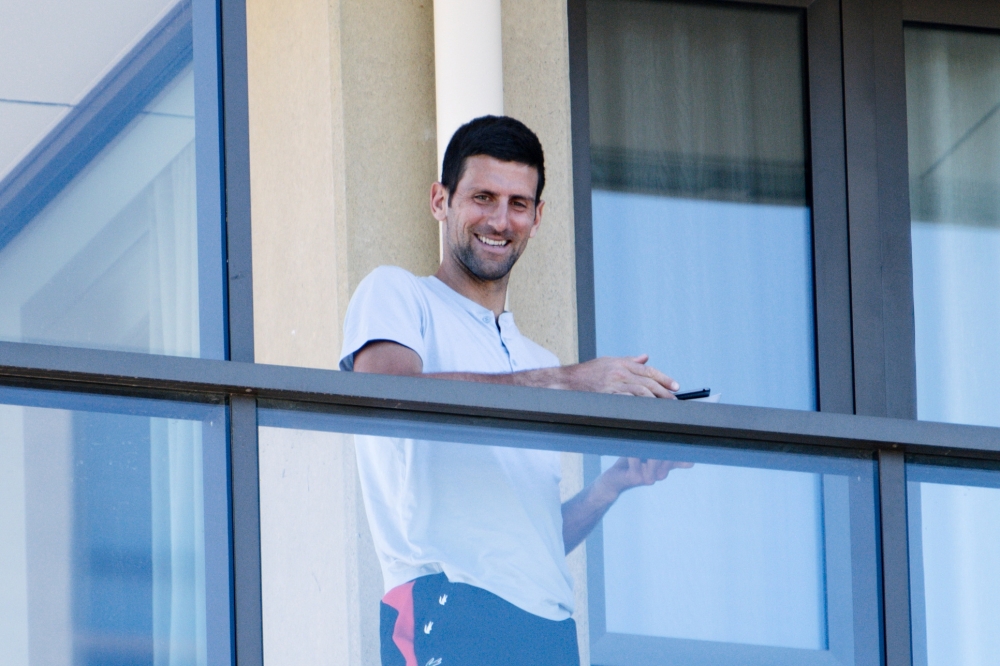 Tennis star Novak Djokovic stands on his balcony at the accommodation where he is quarantining in advance of the Australian Open to be played in Melbourne, in North Adelaide, Australia, January 19, 2021. AAP Image/Morgan Sette 