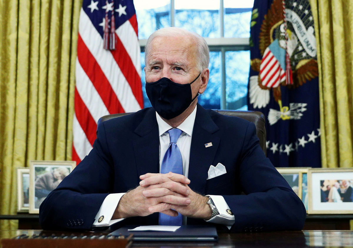 FILE PHOTO: U.S. President Joe Biden signs executive orders in the Oval Office of the White House in Washington, after his Inauguration as the 46th President of the United States, U.S., January 20, 2021. REUTERS/Tom Brenner/File Photo
