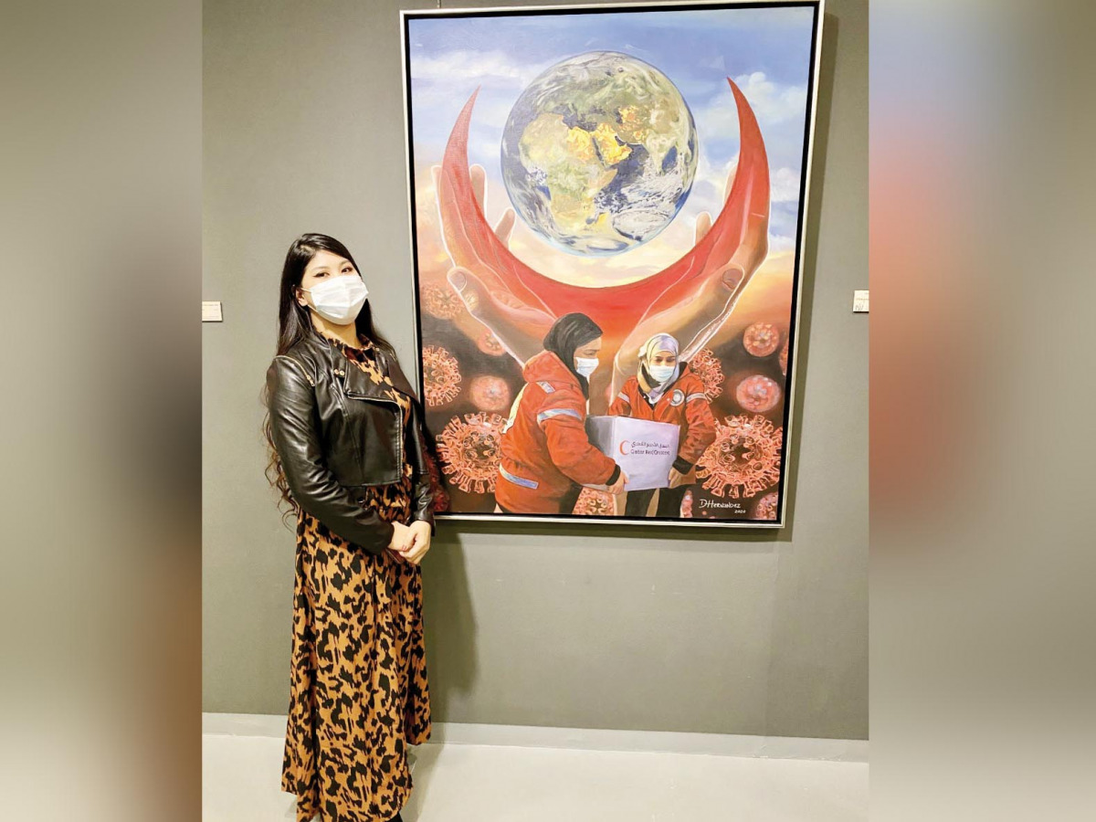 Filipina artist Danica Hernandez, first place winner of art competition organised by Visual Art Center and Qatar Red Crescent Society, poses with her winning painting at the opening of “The Crescent Draws Hope during the COVID-19 Crisis” exhibition yester