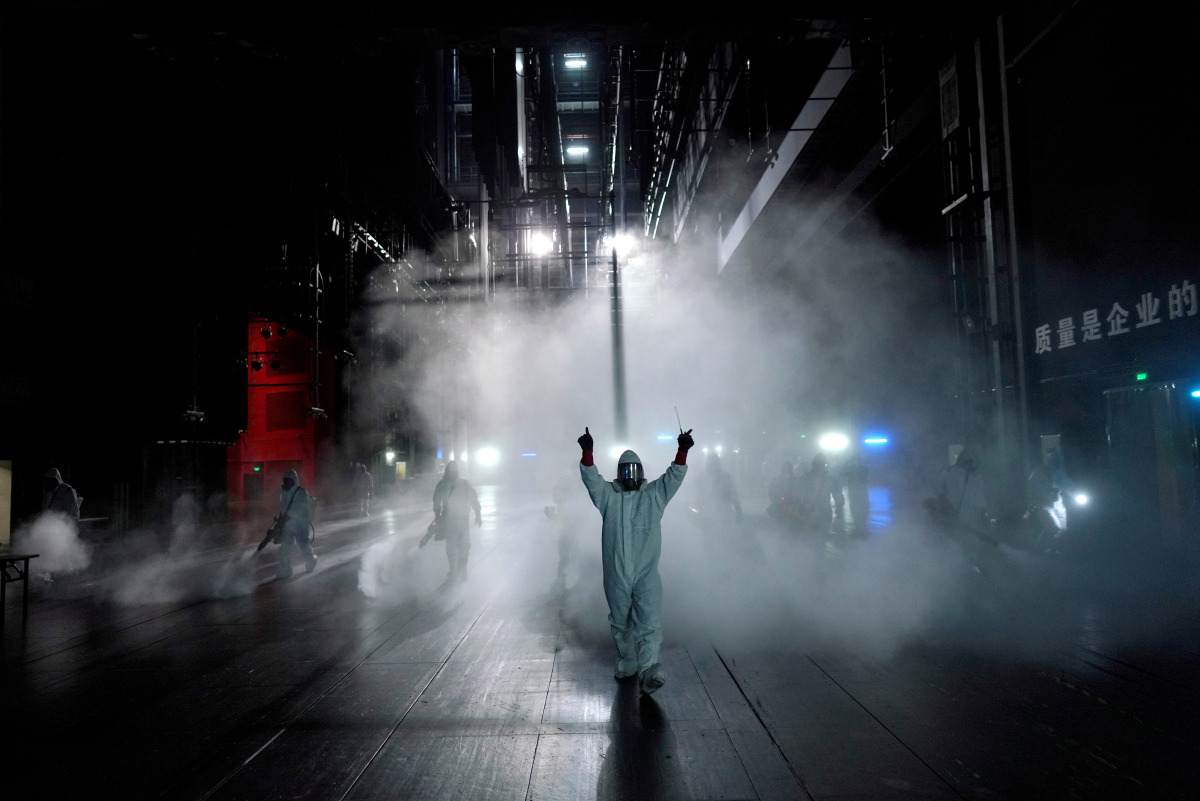 FILE PHOTO: Volunteers from the Blue Sky Rescue team disinfect at the Qintai Grand Theatre in Wuhan, Hubei province, the epicentre of China's coronavirus disease (COVID-19) outbreak, April 2, 2020. REUTERS/Aly Song/File Photo 