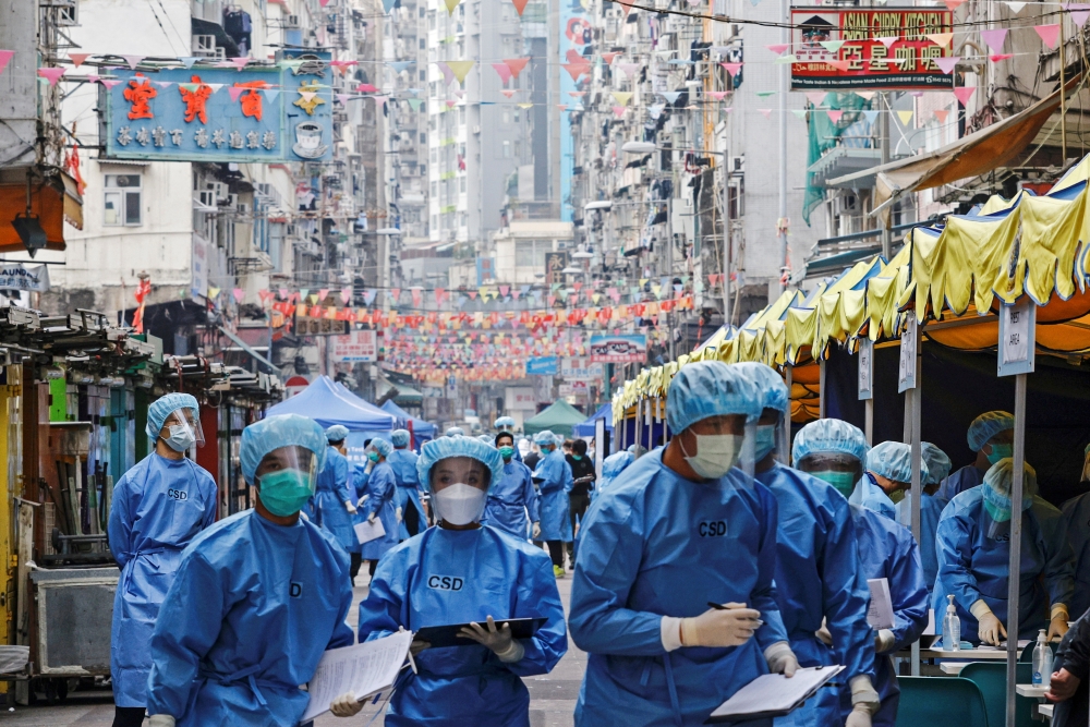 Health workers are seen in protective gear inside a locked down portion of the Jordan residential area to contain a new outbreak of the coronavirus disease (COVID-19), in Hong Kong, China January 23, 2021. REUTERS/Tyrone Siu/File Photo