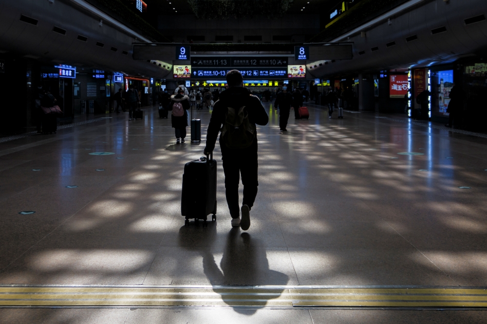 People walk in the Beijing West railway station ahead of upcoming Chinese New Year celebrations following an outbreak of the coronavirus disease (COVID-19) in Beijing, China, January 27, 2021. REUTERS/Thomas Peter