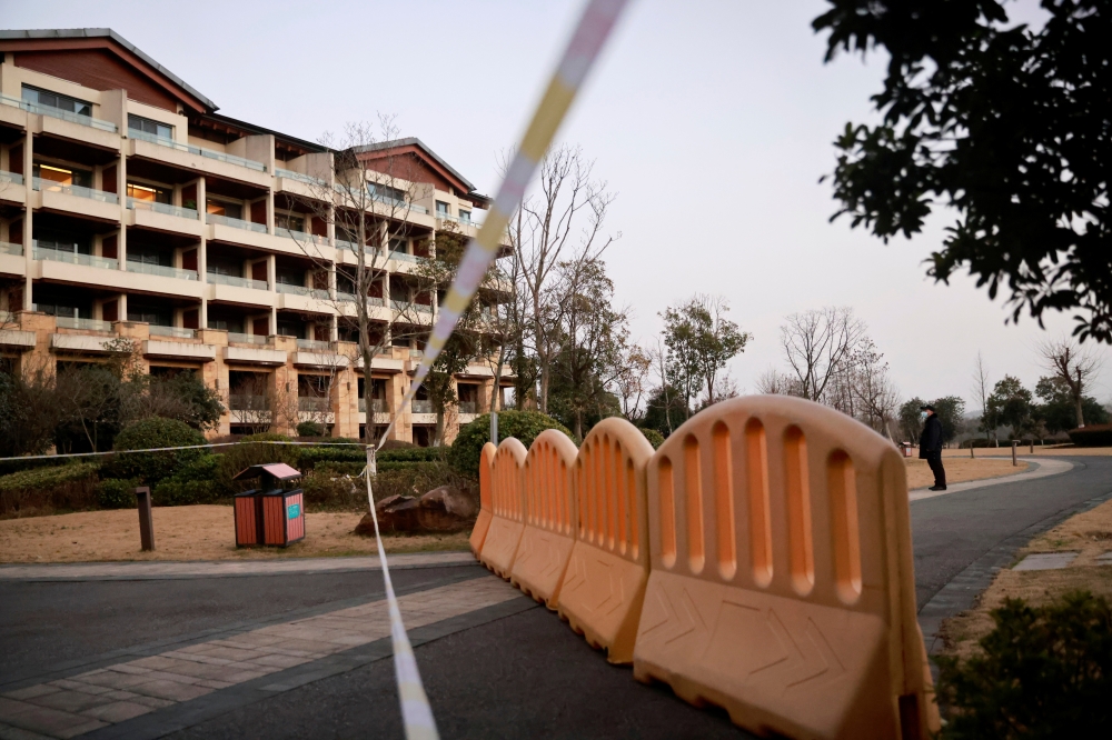 A security member keeps watch at a cordoned-off section of a hotel where members of the World Health Organisation (WHO) team tasked with investigating the origins of the coronavirus disease (COVID-19) went after leaving their quarantine hotel, in Wuhan, H
