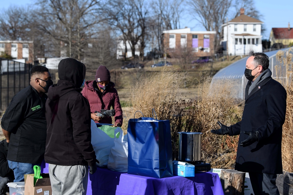 Doug Emhoff, husband of U.S. Vice-President Kamala Harris, speaks with volunteers of Dreaming out Loud, a nonprofit organization focused on food security and economic opportunity, during a visit to the farm at Kelly Miller Middle School, in Washington, U.