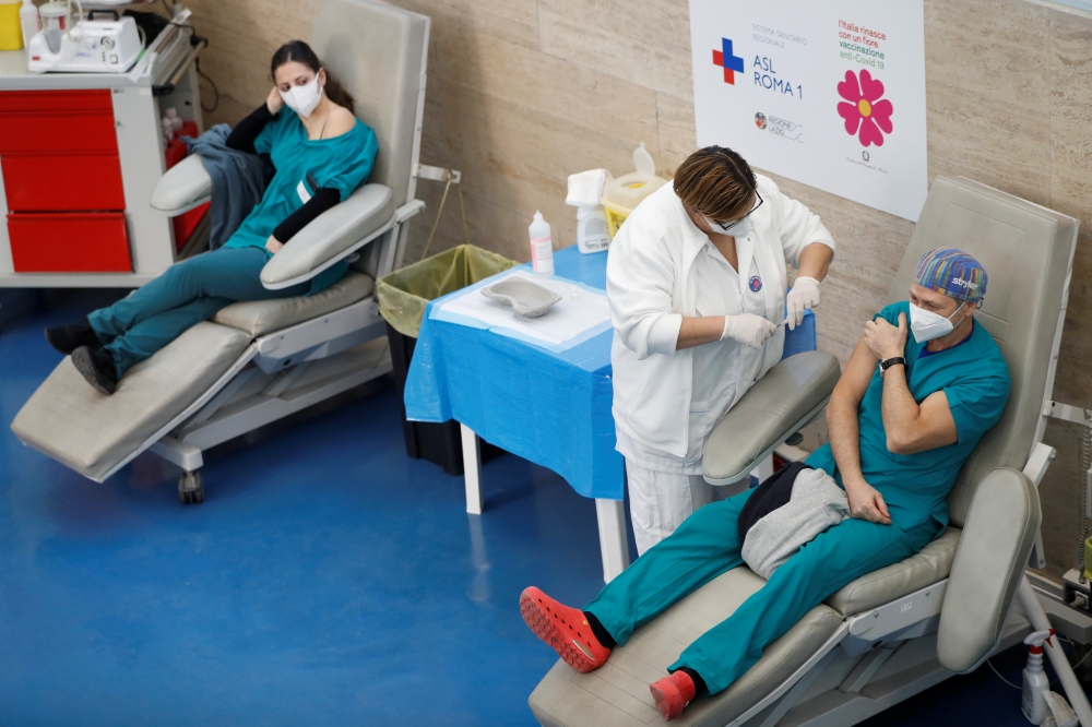 A health care worker receives the second dose of the Pfizer-BioNTech coronavirus disease (COVID-19) vaccine at a vaccination centre in Rome, Italy, January 27, 2021. REUTERS/Yara Nardi