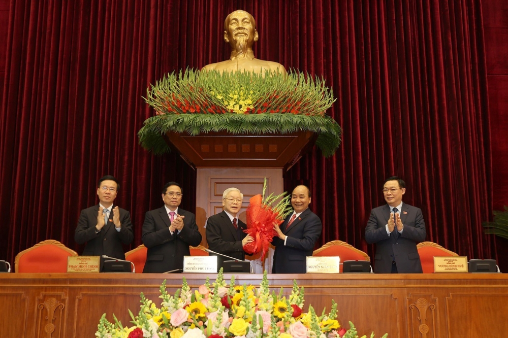 Vietnam's President and General Secretary of the Communist Party Nguyen Phu Trong (3rd L) receives flowers from Prime Minister Nguyen Xuan Phuc after he was re-selected as party chief for a 3rd term in Hanoi, Vietnam January 31, 2021. L-R are politburo me