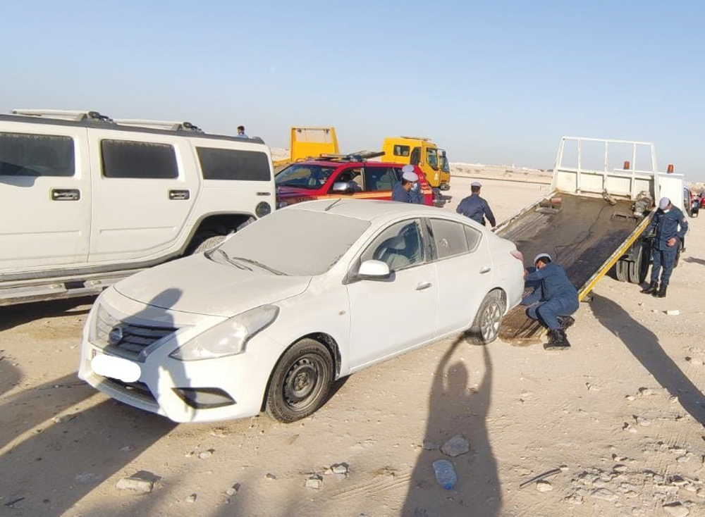 Officials removing an abandoned car in Umm Salal.