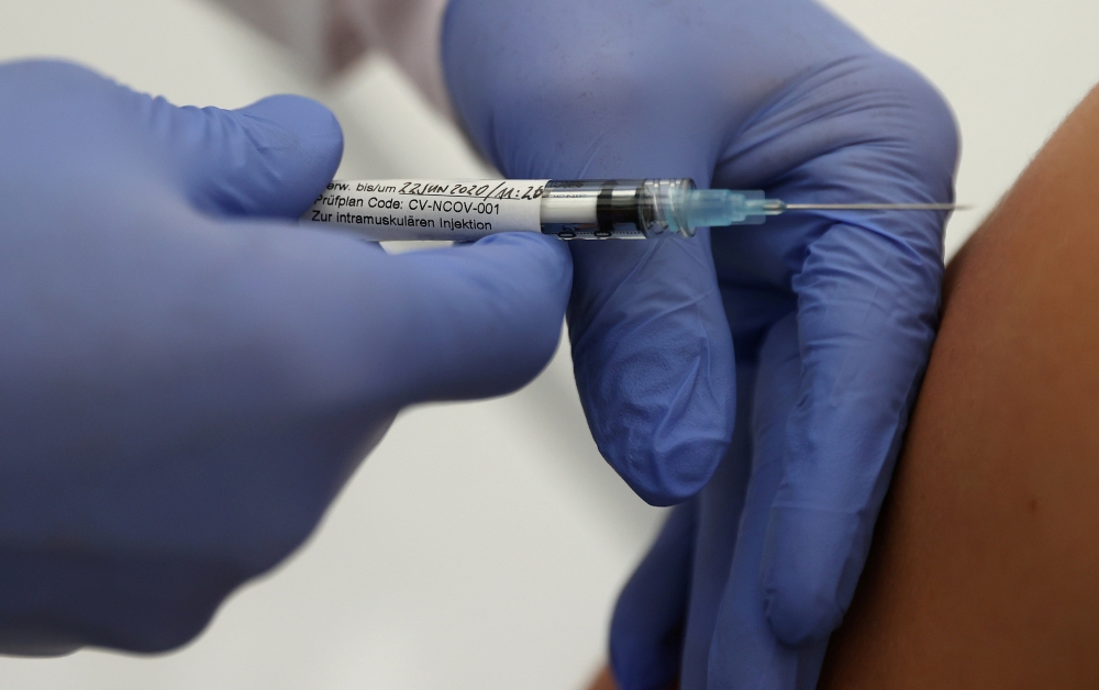 Professor Gottfried Kremsner injects a vaccination against the coronavirus disease (COVID-19) from German biotechnology company CureVac to a volunteer at the start of a clinical test series at his tropical institute of the university clinic in Tuebingen, 