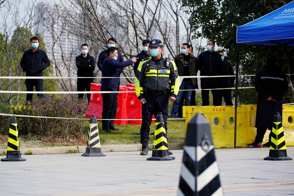 Security members keep watch outside the venue where members of the World Health Organization (WHO) team tasked with investigating the origins of the coronavirus disease (COVID-19) are expected to hold a news conference, at a hotel in Wuhan, Hubei province