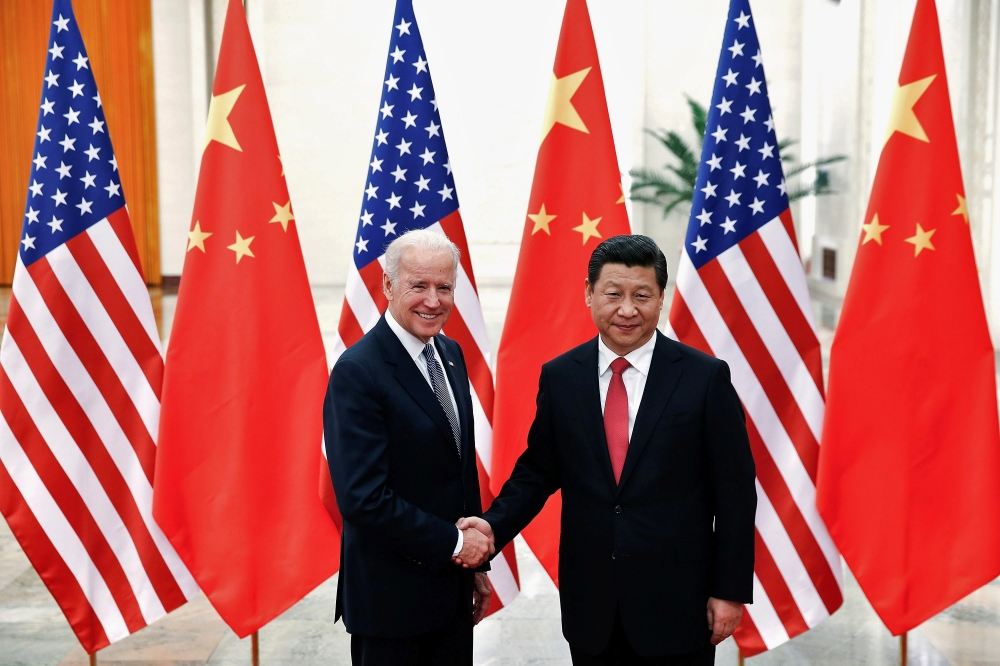 File photo: Chinese President Xi Jinping shakes hands with U.S. Vice President Joe Biden (L) inside the Great Hall of the People in Beijing December 4, 2013. Reuters/Lintao Zhang/Pool//File Photo