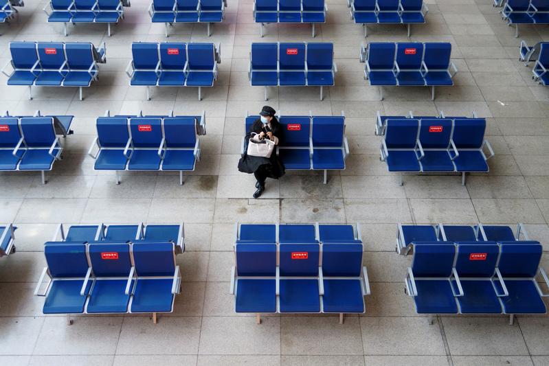 FILE PHOTO: A woman waits in the departure hall of Beijing South Railway station ahead of Lunar New Year celebrations following an outbreak of the coronavirus disease (COVID-19) in Beijing, China, February 10, 2021. REUTERS/Thomas Peter/File Photo
