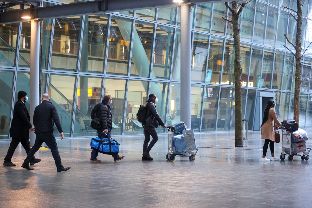 Travellers arrive at Heathrow Airport, as Britain introduces hotel quarantine programme for arrivals from a 