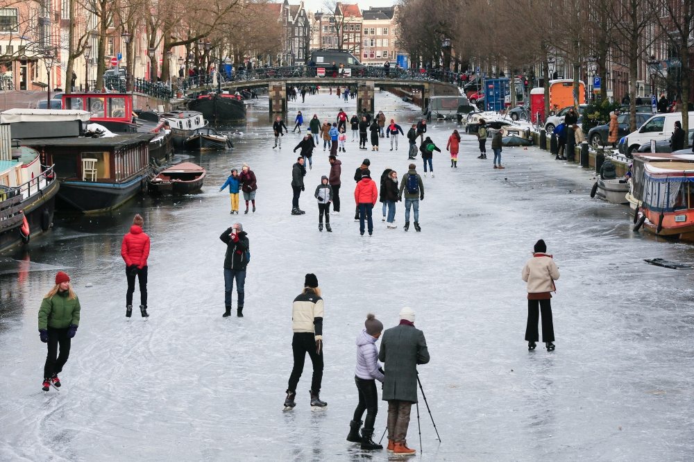 People ice skate during a cold snap across the country at the Prinsengracht in Amsterdam, Netherlands February 14, 2021. Reuters/Eva Plevier