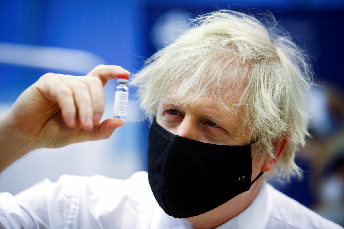 FILE PHOTO: Britain's Prime Minister Boris Johnson holds a vial of an Oxford-AstraZeneca COVID-19 vaccine, during his visit at a vaccination centre at Cwmbran Stadium in Cwmbran, south Wales, Britain February 17, 2021. Geoff Caddick/Pool via REUTERS/File 
