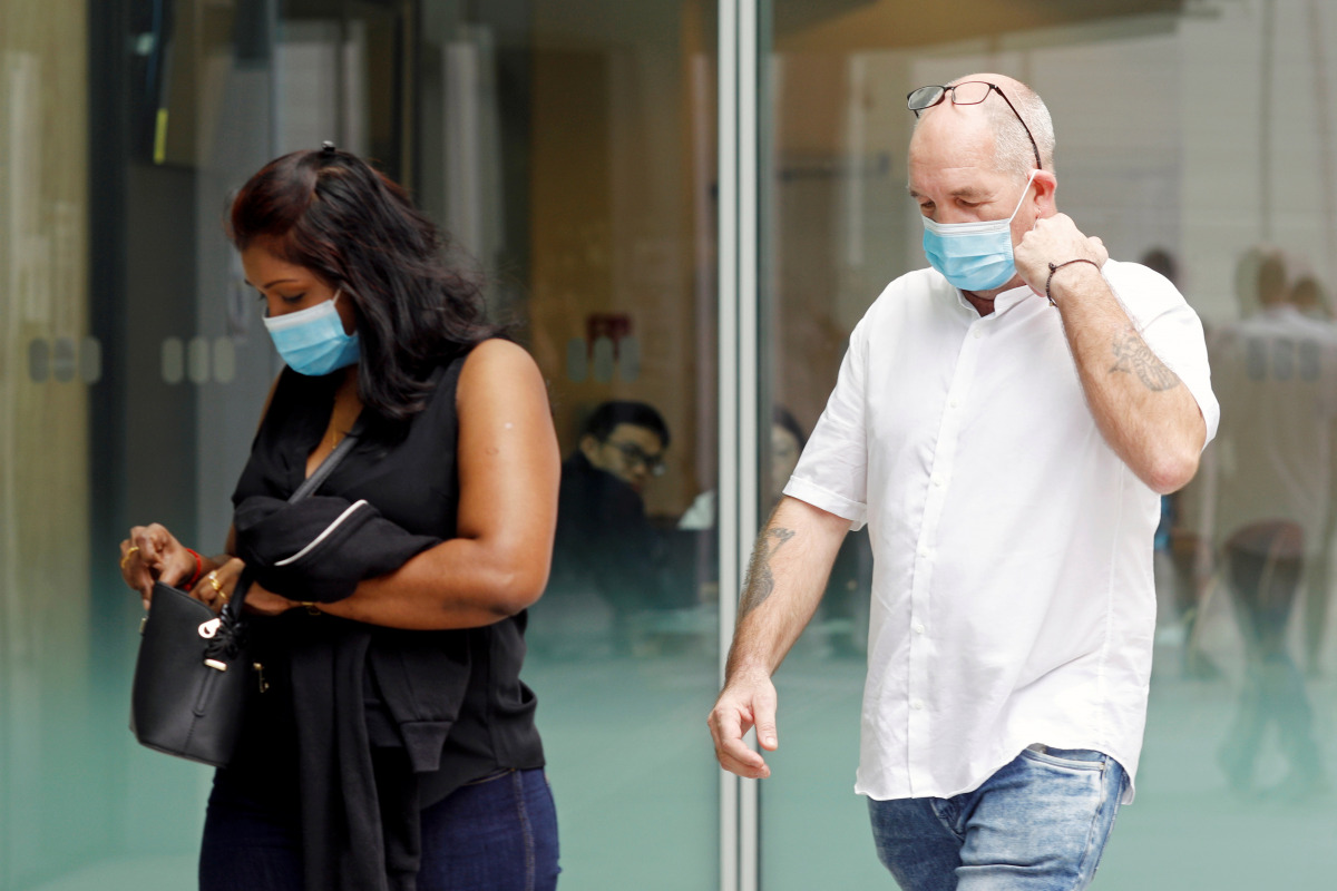Briton Skea Nigel and partner Agatha Maghesh Eyamalai arrive at the State Courts for a hearing after breaking coronavirus disease (COVID-19) quarantine regulations in Singapore February 15, 2021.  REUTERS/Edgar Su