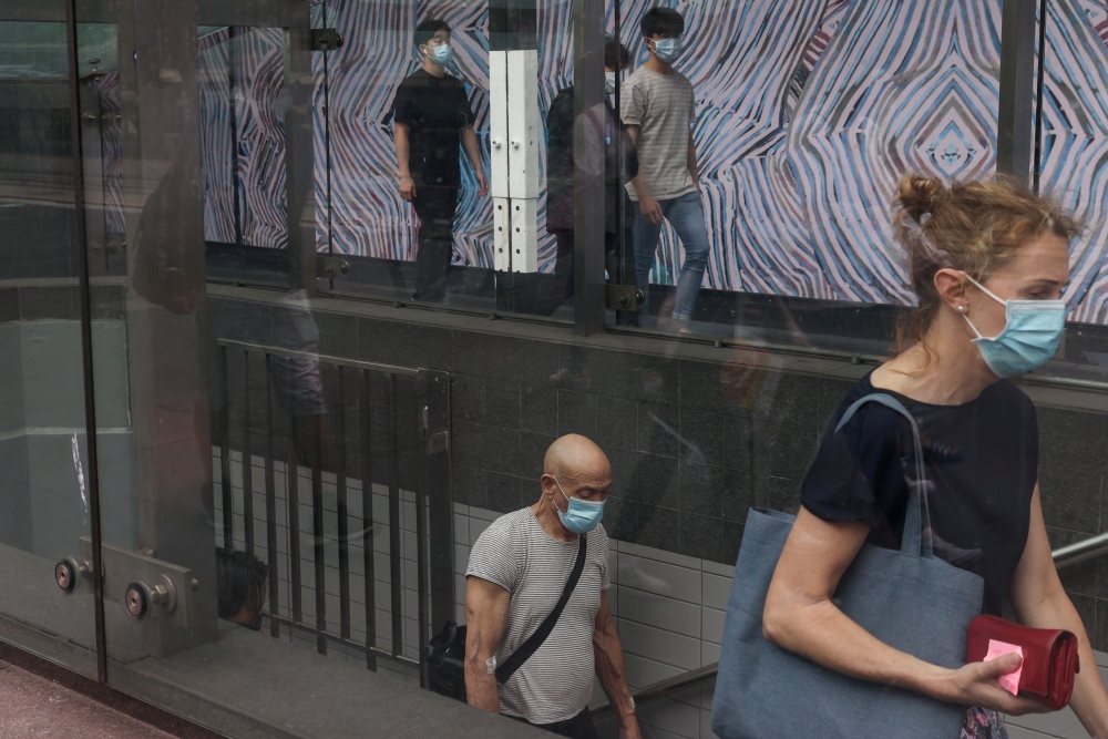 Commuters wearing protective face masks in accordance with new public health regulations for riding public transit depart a train station in the wake of a coronavirus disease (COVID-19) outbreak in Sydney, Australia, January 6, 2021. REUTERS/Loren Elliott
