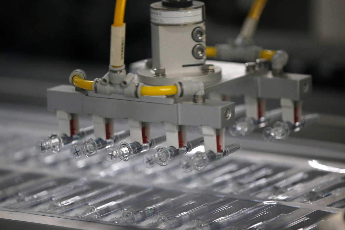 FILE PHOTO: COVID-19 vaccines are seen on a production line REUTERS/Tingshu Wang
