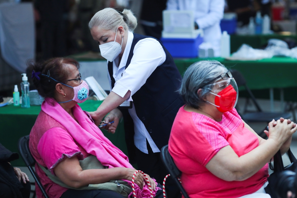 A woman receives the Pfizer-BioNTech coronavirus disease (COVID-19) vaccine during a mass vaccination in Mexico City, Mexico March 10, 2021. Reuters/Henry Romero