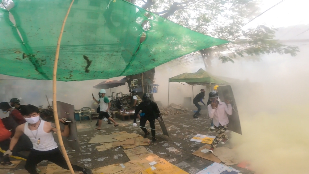 Protesters run during an anti-coup protest on a street in Yangon, Myanmar March 12, 2021 in this still image taken from social media video obtained by REUTERS.