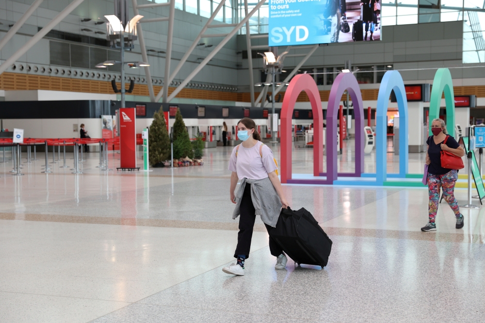 File photo: People wearing masks walk through a mostly empty domestic terminal at Sydney Airport in Sydney, Australia, December 21, 2020. Reuters/Loren Elliott/File Photo