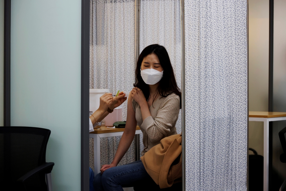 A health worker gets a dose of the Pfizer-BioNTech coronavirus disease (COVID-19) vaccine at a COVID-19 vaccination center in Seoul, South Korea, March 10, 2021. REUTERS/Kim Hong-Ji