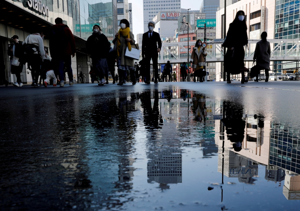 Pedestrians wearing protective masks amid the coronavirus disease (COVID-19) outbreak, make their way in Tokyo, Japan, February 2, 2021. REUTERS/Kim Kyung-Hoon/File Photo