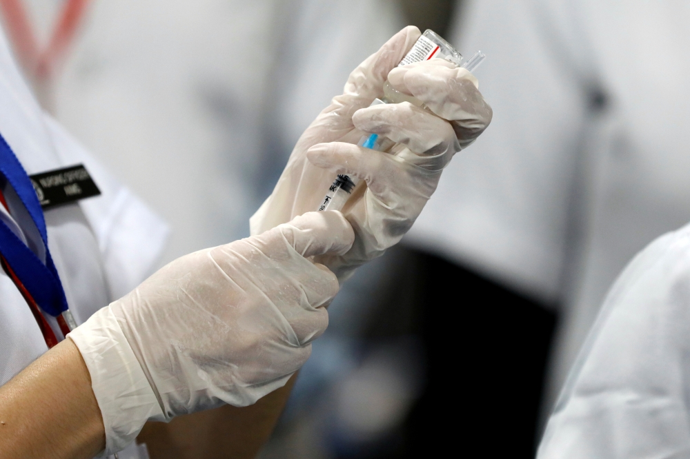A healthcare worker fills a syringe with a dose of Bharat Biotech's COVID-19 vaccine called COVAXIN, during the coronavirus disease (COVID-19) vaccination campaign at All India Institute of Medical Sciences (AIIMS) hospital in New Delhi, India, January 16