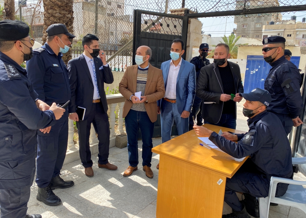 Men speak with police officers as Palestinians begin registering party lists for May parliamentary election, at the Palestinian Central Elections Commission's office in Gaza City March 20, 2021. REUTERS/Mohammed Salem