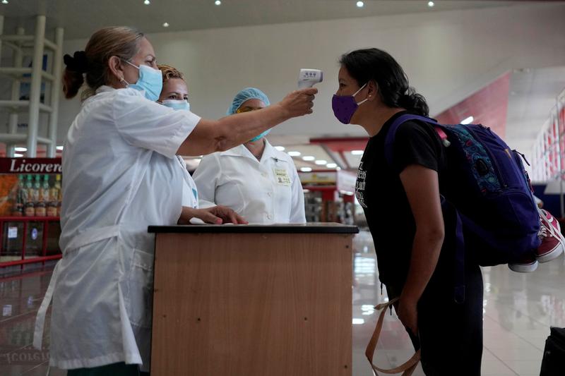 FILE PHOTO: A traveller has her temperature checked at the Jose Marti International Airport amid concerns about the spread of the coronavirus disease (COVID-19), in Havana, Cuba, November 15, 2020. REUTERS/Alexandre Meneghini/File Photo
