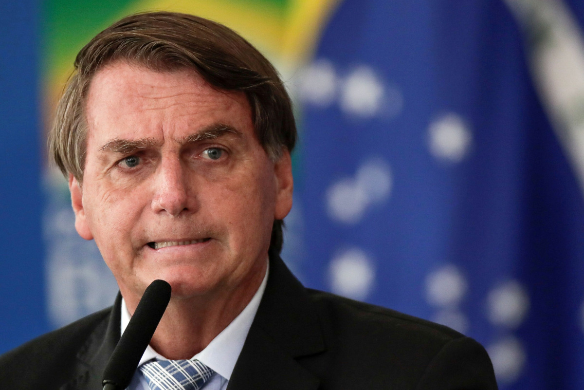 FILE PHOTO: Brazil's President Jair Bolsonaro reacts during a ceremony to expand the ability of the government to purchase vaccines against COVID-19, amid the coronavirus disease (COVID-19) outbreak, in Brasilia, Brazil, March 10, 2021. REUTERS/Ueslei Mar