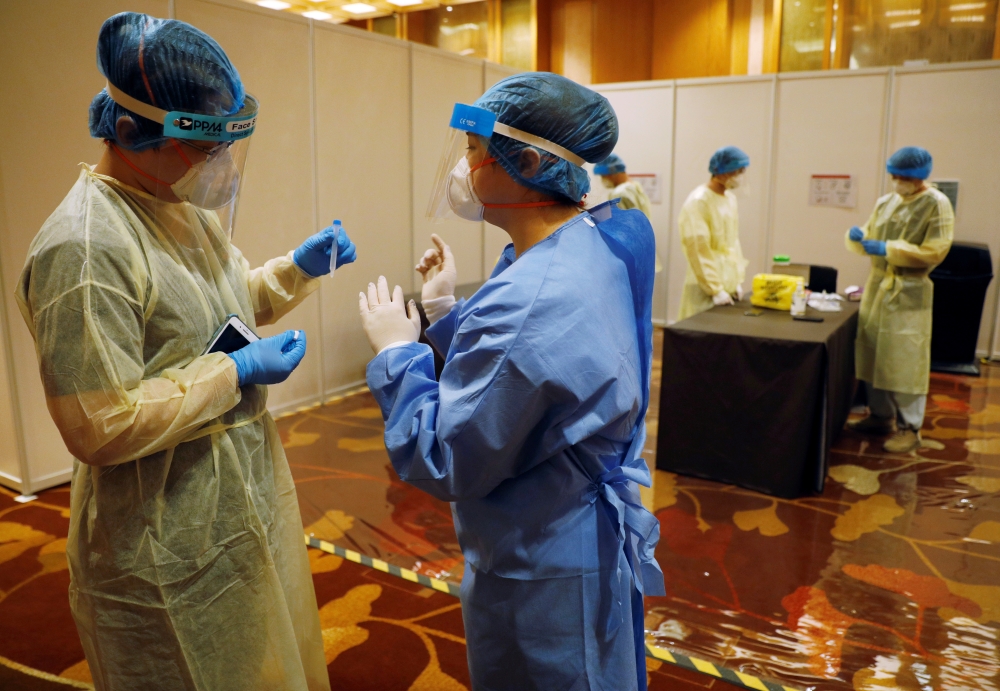 Medical workers are seen at a coronavirus disease (COVID-19) rapid antigen test center at Geo Connect Asia trade conference in Singapore March 24, 2021. REUTERS/Edgar Su