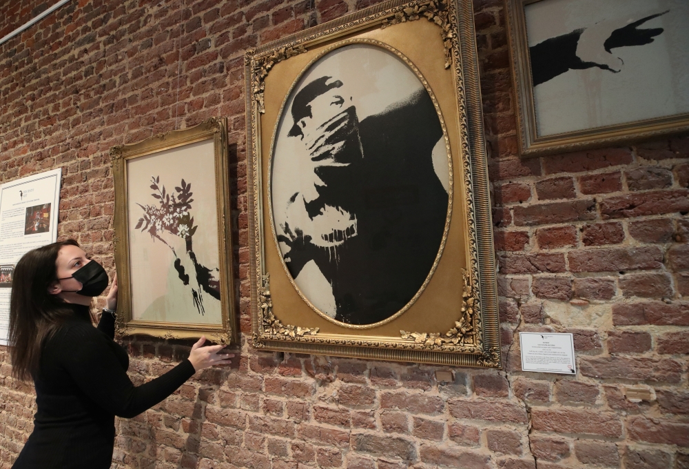 An art handler shows to reporters work 