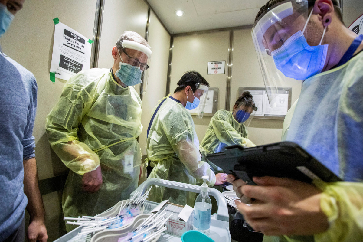 Nurses and doctors from Humber River Hospital ride an elevator as they prepare to administer the Moderna coronavirus disease (COVID-19) vaccine at a Toronto Community Housing seniors building in the northwest end of Toronto, Ontario, Canada March 25, 2021