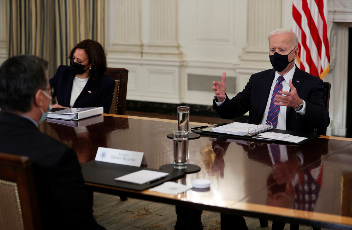 U.S. President Joe Biden is flanked by Vice President Kamala Harris as he speaks with HHS Secretary Xavier Becerra during a meeting with immigration advisers in the State Dining Room at the White House in Washington, U.S., March 24, 2021. REUTERS/Jonathan
