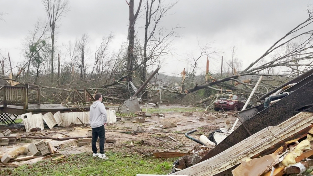 A man looks at damage and debris in the aftermath of a tornado in Centreville, Alabama, U.S. March 25, 2021, in this still image obtained from a social media video. Courtesy of Brayden Siau/Social Media via REUTERS