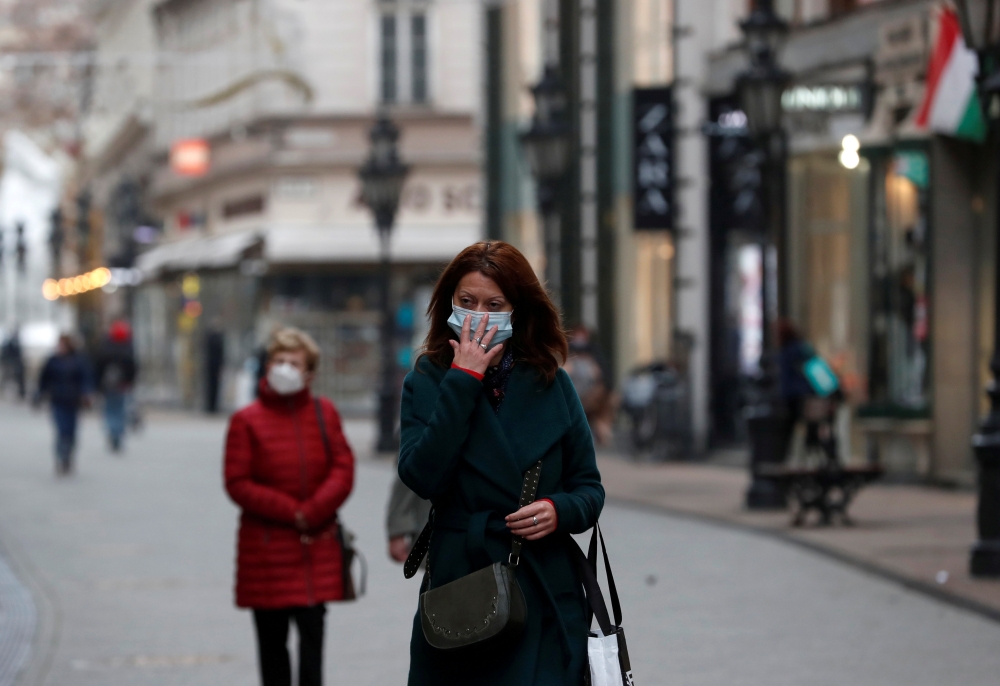 People wearing protective face masks walk in downtown Budapest, after Hungarian government imposed a nationwide lockdown to contain the spread of the coronavirus disease (COVID-19), Hungary, November 11, 2020. REUTERS/Bernadett Szabo/Files/File Photo
