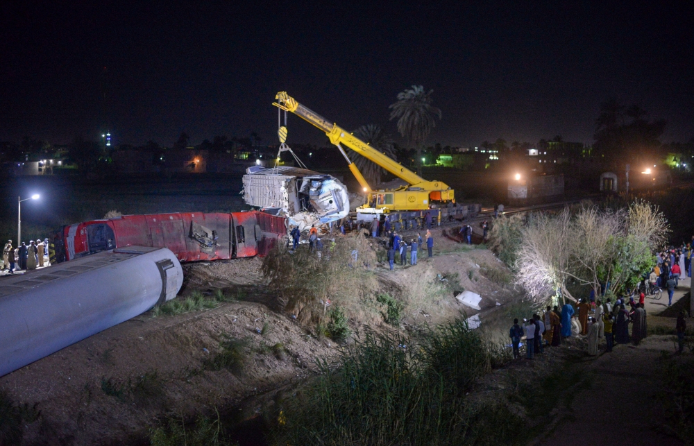 People inspect the damage after two trains have collided near the city of Sohag, Egypt, March 26, 2021. Picture taken March 26, 2021 REUTERS/Meritt Elsayed Ali
