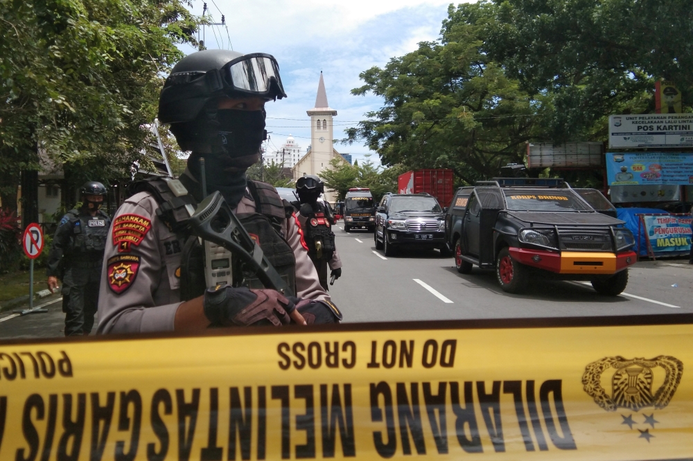 Armed police officers stand guard along a closed road following an explosion outside a Catholic church in Makassar, South Sulawesi province, Indonesia, March 28, 2021 in this photo taken by Antara Foto. Antara Foto/Arnas Padda/ via REUTERS 
