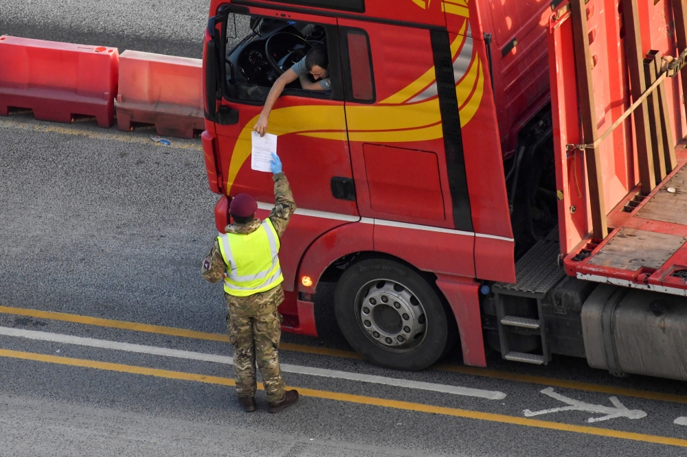 A military officer checks documents as a lorry driver waits to enter the Port of Dover in preparation for crossing the channel to France, following the coronavirus disease (COVID-19) outbreak, in Dover, Britain December 31, 2020. REUTERS/Toby Melville/Fil
